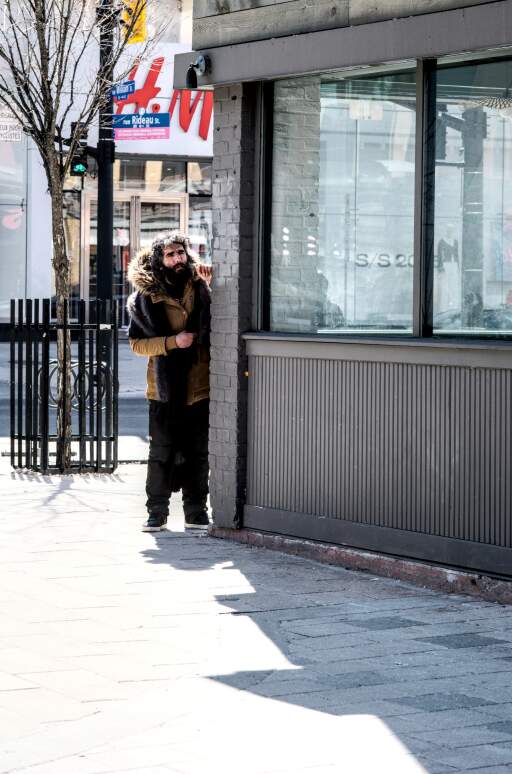 A homeless person popping his head around the street corner, interesting