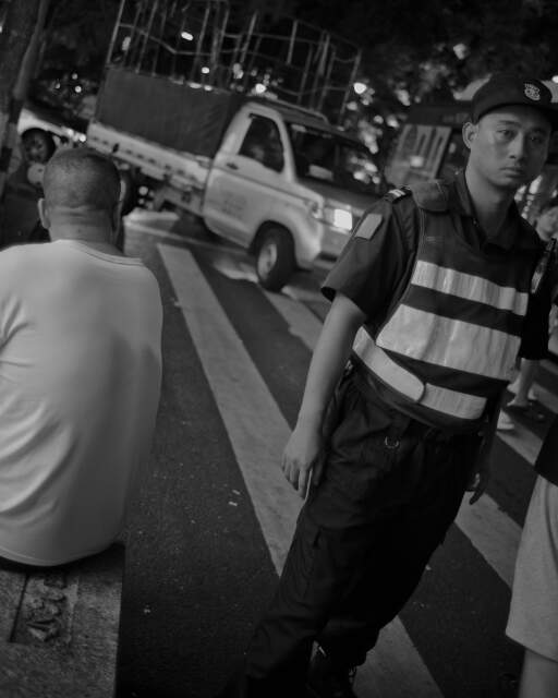 The triangle formed by the truck, the security, and the seated man is interesting, as is the expression on the security's face. 